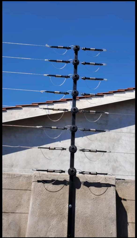Close-up of electric fence wires, springs and insulators