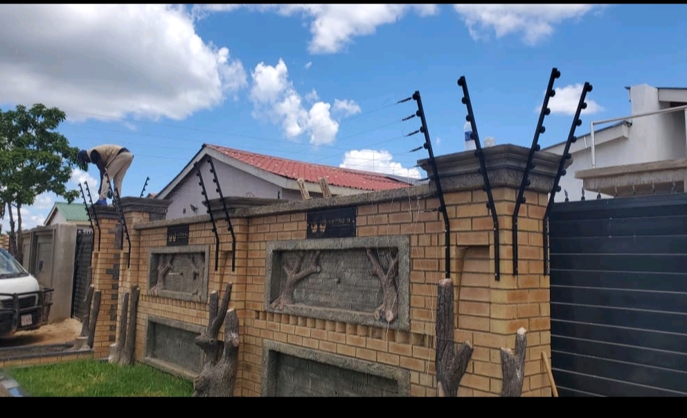 Electric fence installation on brick perimeter wall