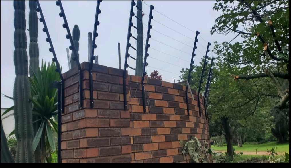 Electric fence wires mounted on brick pillar